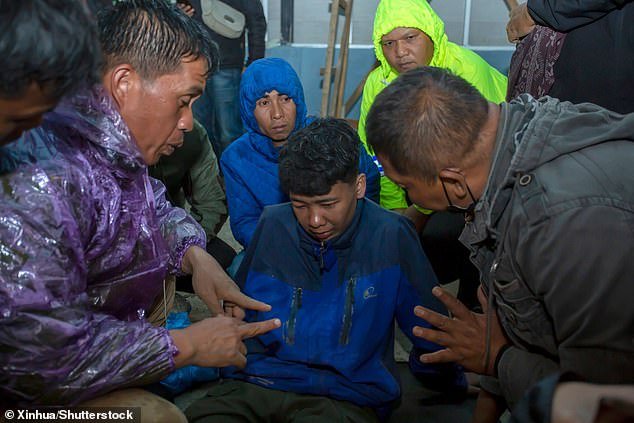 Rescue workers talk to a man affected by Monday's volcanic eruption in Marapi, Indonesia