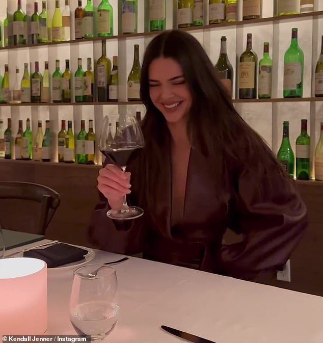 Kendall's table was in front of a wall of bottles and she captioned the post: 'Me and my wine again'