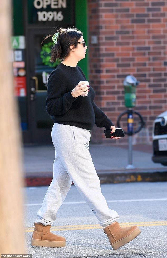 The actress paired the crew neck with gray bottoms while holding a small hot drink