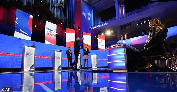 Stand-ins take positions of candidates and moderators to control sound and lighting prior to a Republican presidential primary debate hosted by NewsNation on Wednesday, Dec. 6, 2023, at the Moody Music Hall at the University of Alabama in Tuscaloosa, Ala.  (AP Photo/Gerald Herbert)