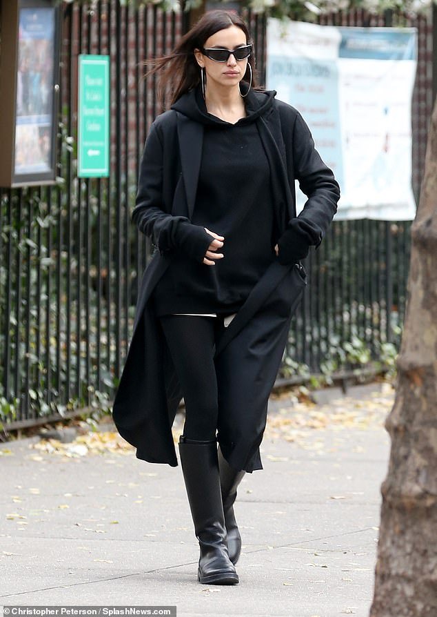 The Sports Illustrated Swimsuit Issue alum, 37, wore black leggings with a thin white stripe high up her thighs with a black hoodie, a long black coat and black, knee-high boots