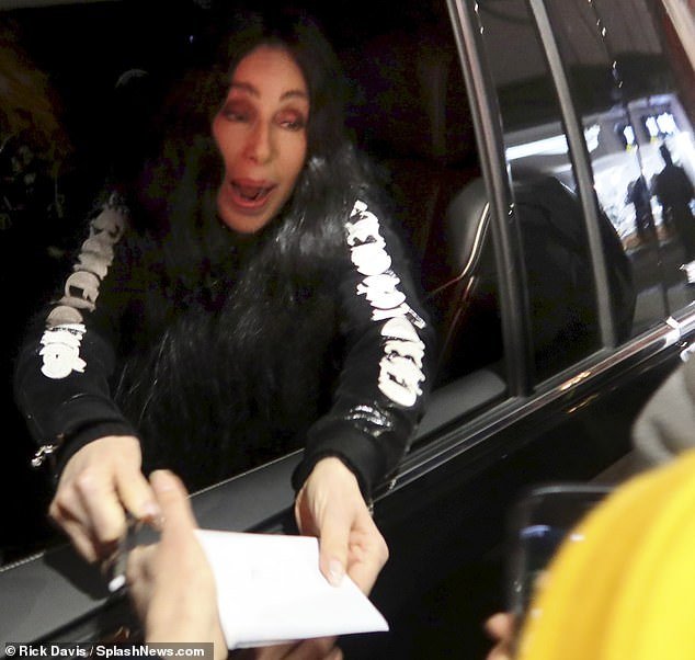 After climbing into her car to run away, she could be seen leaning out the window to kindly sign an autograph for a fan.