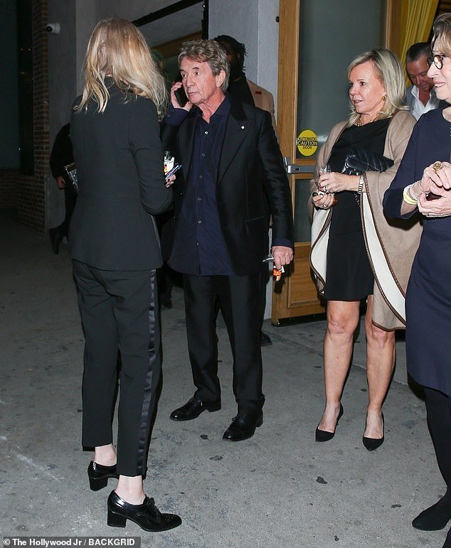 The proud dad looked handsome in a classic black suit and navy blue shirt as he greeted guests attending the party at Grand Master Recorders in Hollywood