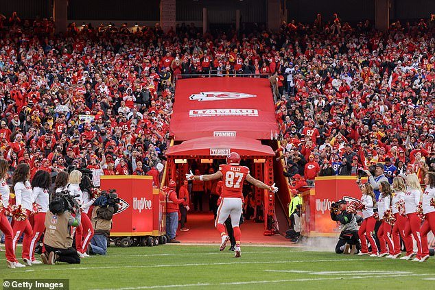 Kelce runs out of the tunnel to loud applause, while his high-profile girlfriend looks on
