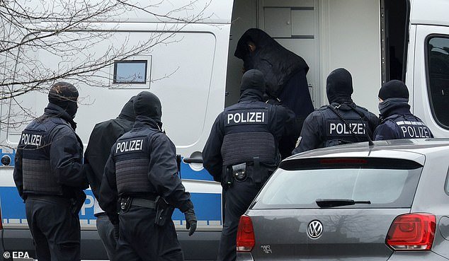 Federal police officers lead two suspects out of the helicopter on Friday for their arraignment at the Federal Supreme Court (BGH) in Karlsruhe, Germany