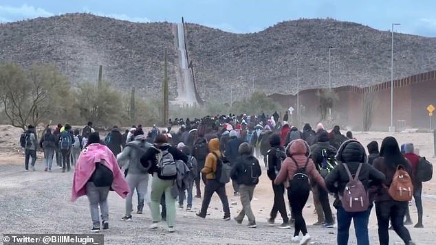 Photos and videos from Lukeville, Arizona, show hundreds of newcomers carrying backpacks and walking their meager belongings along the wall