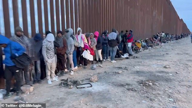 Asylum seekers line the border wall near Lukeville waiting to surrender to border agents