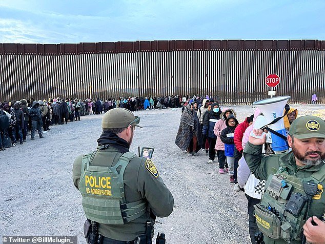 Border Patrol agents herd hundreds of migrants into lines at a processing center