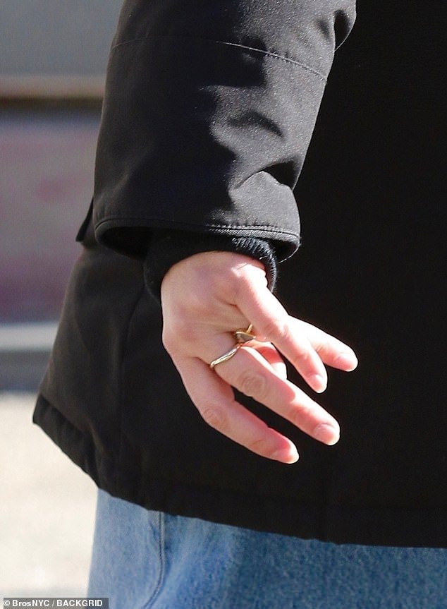 Greta, 40, wore a gold band on her wedding ring finger, a winter coat, turtleneck, flared denim and a beanie
