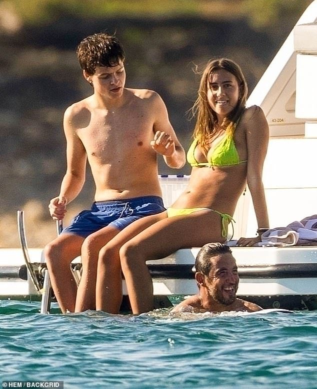 The teen, who favors his musical dad, relaxed with a bikini-clad friend