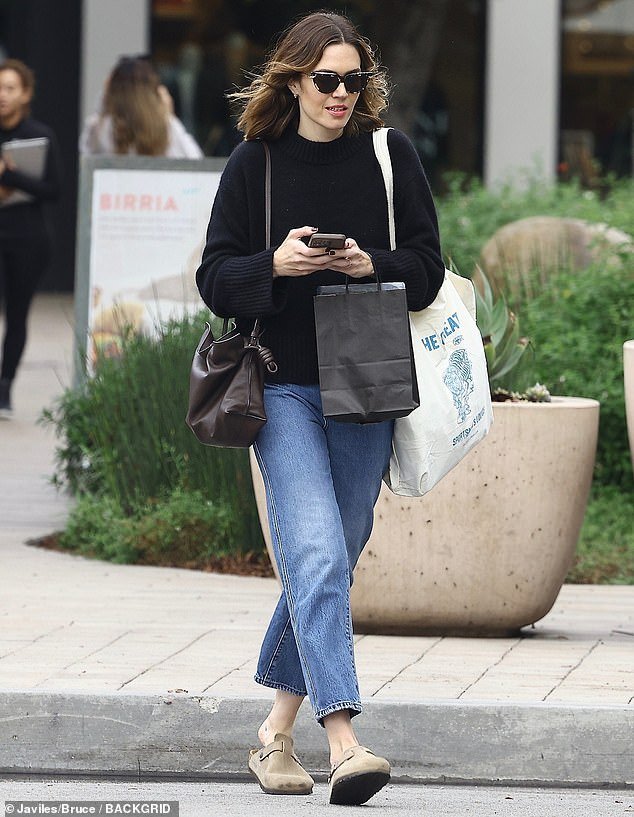 The artist stayed comfortable in a black sweater and loose-fitting jeans while out shopping