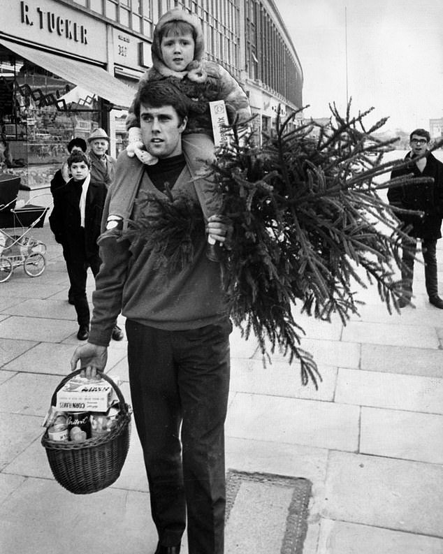 Even footballers leave their Christmas shopping at the last minute as Geoff Hurst carries a shopping basket, a tree and his daughter Claire on his shoulders on December 23, 1968.