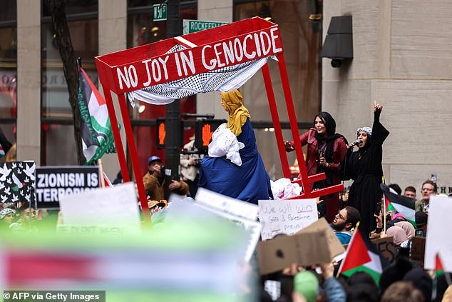 A bright red nativity scene reading 'no joy in genocide' was a central part of the protest as it passed through the Big Apple on Christmas Day