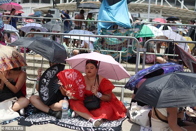 Taylor Swift fans used umbrellas to protect themselves from the extreme heat as they waited to enter the concert venue