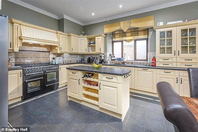 The kitchen has cream colored wall and base units with contrasting worktops and space for a dining table