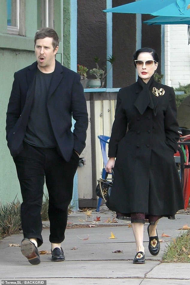 The 51-year-old burlesque dancer showed off her vintage style in a black peacoat and matching '50s dress as the couple had lunch in the tony town of Los Feliz