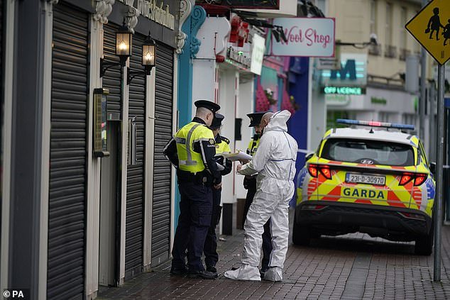 A forensic investigator speaks to Garda officers at the scene in Blanchardstown, Dublin on December 25, 2023, a day after Sherry entered and opened fire on a man in his 40s