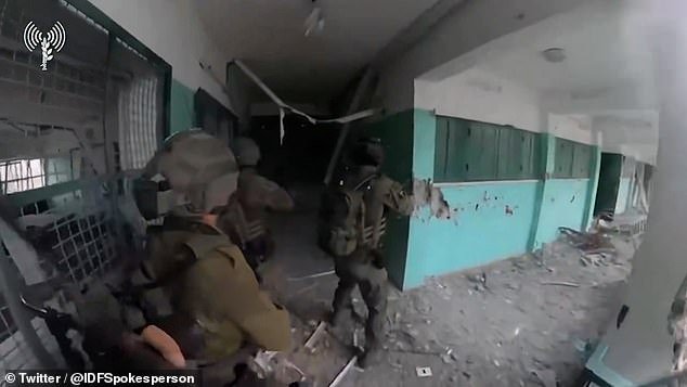 The footage shows Israeli soldiers shooting in a dark corridor within the school complex