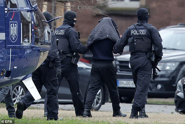 Federal police officers lead two suspects out of the helicopter on Friday for their arraignment at the Federal Supreme Court (BGH) in Karlsruhe, Germany