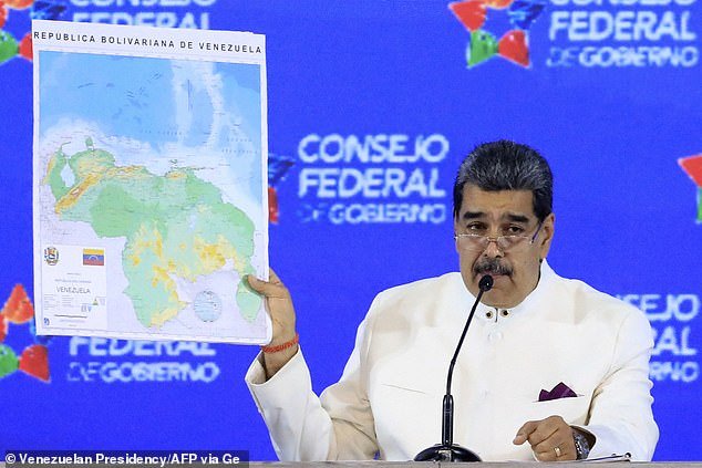 Venezuela's President Nicolas Maduro is seen Tuesday holding up his new map of the region, which shows Guyana Esequiba, a region the size of Florida, under Venezuelan control