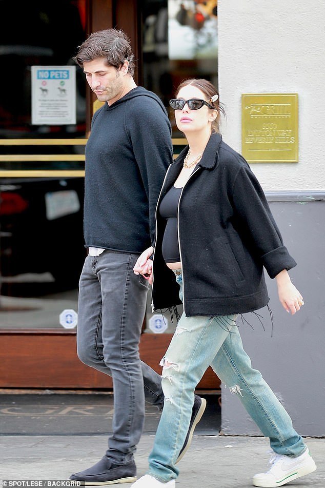 Ashley Benson showed off her baby bump as she stepped out with her husband Brandon Davis in Los Angeles on Wednesday