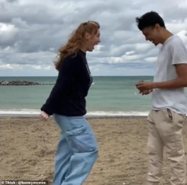 A young man set up his camera to capture an extremely important proposal while visiting an empty beach in October with his girlfriend, who reacts after being overwhelmed with joy