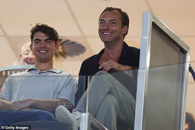 Law sat in the stands as he took his actor son Rudy (left) aside during the tennis match