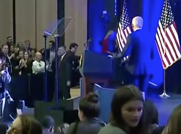 Biden remained standing on stage as Jill Biden rushed to escort him from the stage