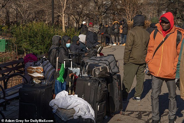 Mobs of migrants queued outside a New York processing center in freezing weather as some revealed they had been waiting for a bed for a month