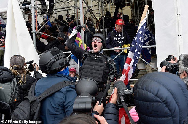 A man calls on people to invade the building as Trump supporters clash with police and security forces as they try to storm the US Capitol in Washington DC on January 6, 2021.