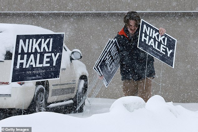 A volunteer for Nikki Haley's presidential campaign pulls up signs after her event at Horizon Family Restaurant was canceled due to a snowstorm, wreaking havoc on Republican candidates' plans