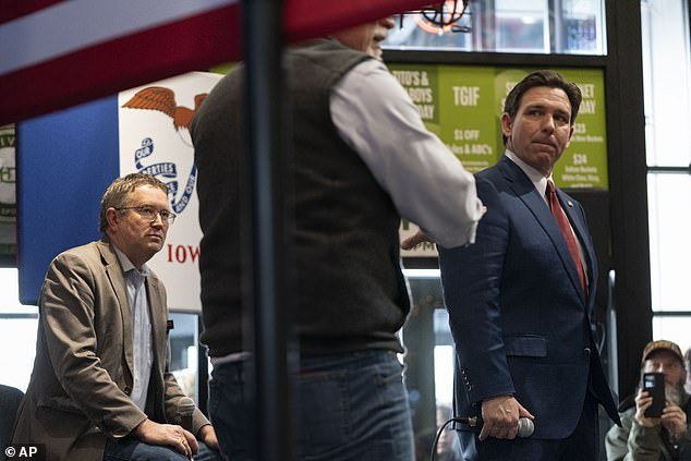 Rep. Thomas Massie (left) told DailyMail.com that frigid caucus night temperatures would help Florida Governor Ron DeSantis (right), who joked at McDivot's Indoor Sports Pub on Sunday that he hadn't brought warm enough clothes for the weather. Monday