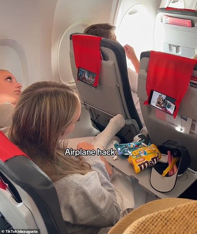The 10-second clip ended with them watching in-flight entertainment on their phones, which hung on the backs of the seats in front of them.