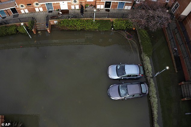 Two cars were left abandoned in a flooded car park near the River Thames in Oxford on Sunday after a week of heavy rain saturated the land
