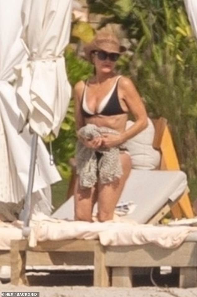 Richards wore a black two-piece swimsuit with a mesh cover-up, and completed the look with a beige Western-style hat and sunglasses