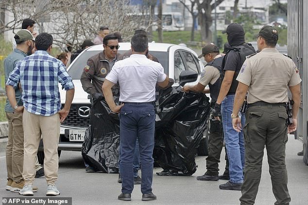Members of the National Police move the body of prosecutor Cesar Suarez to Guayaquil