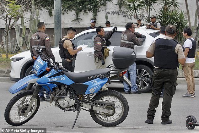 Members of the National Police inspect the car in which prosecutor Cesar Suarez was sitting at the time he was shot dead