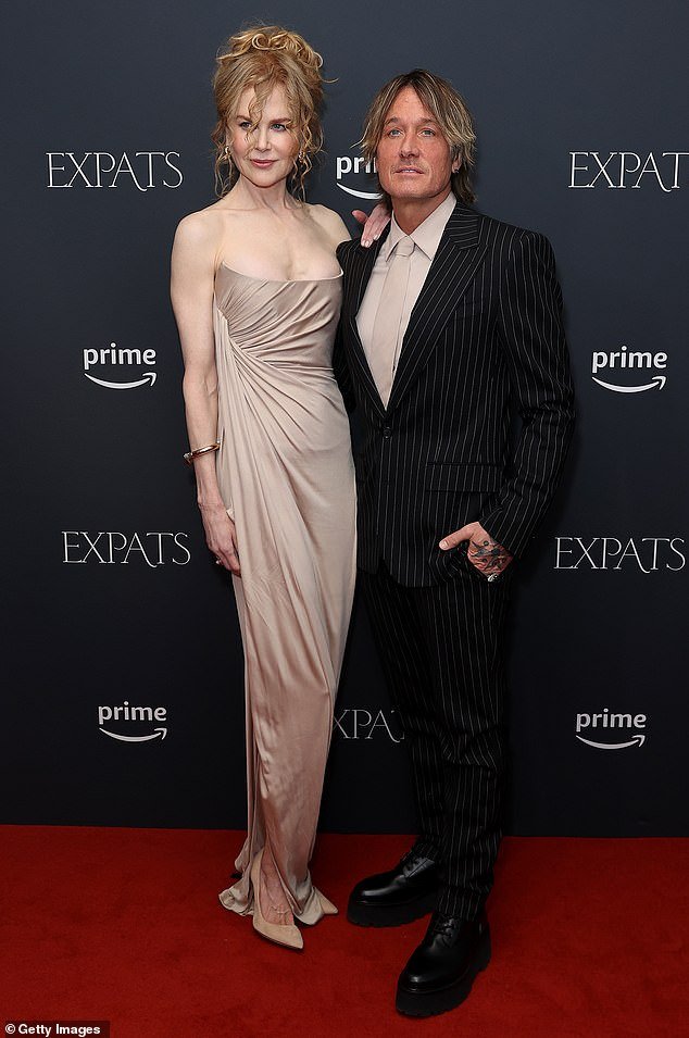 Nicole revealed her smooth, porcelain face as she walked the red carpet with her husband Keith Urban in a flowing champagne dress