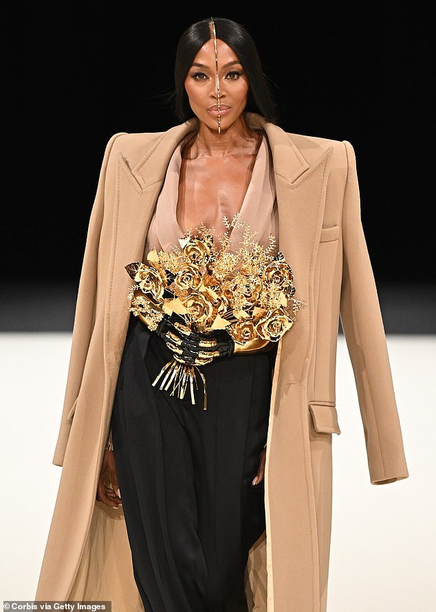 Naomi looked sensational in the bizarre ensemble which also included a daringly plunging blouse and high-waisted trousers