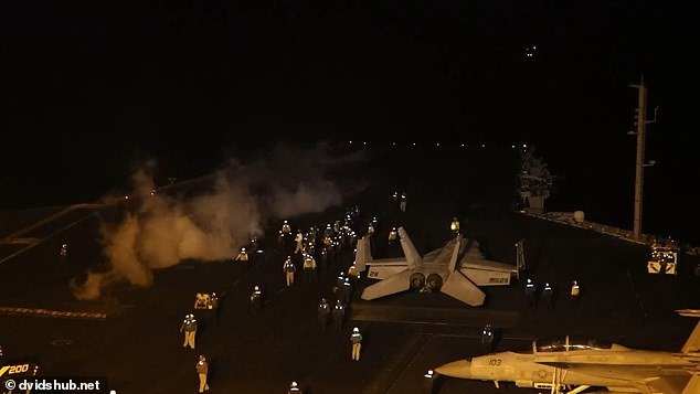 Crew aboard the USS Dwight D. Eisenhower prepares fighter jets for launch
