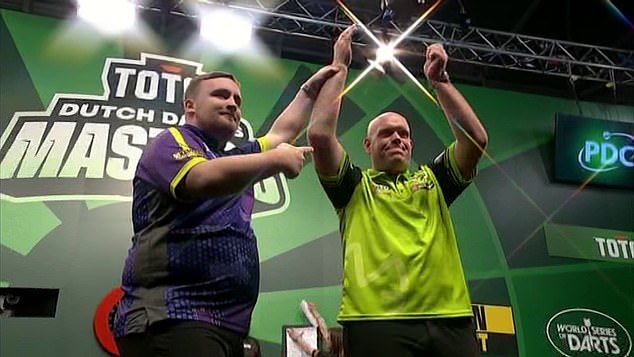 The 17-year-old was defeated 8-6 by three-time world champion Michael Van Gerwen (right)
