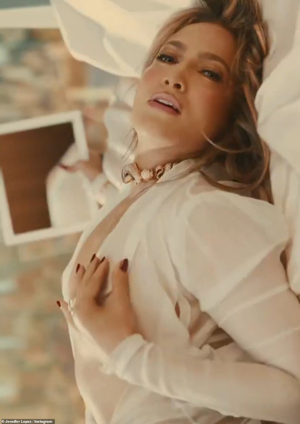 The hitmaker is also seen touching her chest while wearing a white outfit