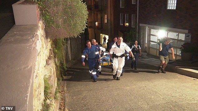 The photo shows emergency workers carrying the woman on a stretcher