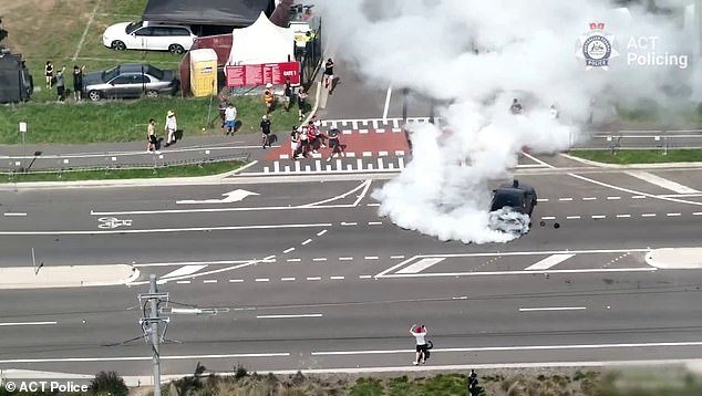 One revhead was captured by a Federal Police drone testing its wheels, with the black Holden Commodore spinning in circles and sending up huge plumes of smoke just meters from pedestrians on Flemington Road