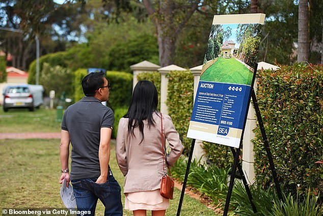 Analysts have predicted that Australian house prices are likely to fall this year (see a sign for a house auction in Sydney's Beacon Hill)
