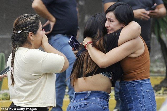 Relatives of prosecutor Cesar Suarez cry at the scene where Suarez was shot