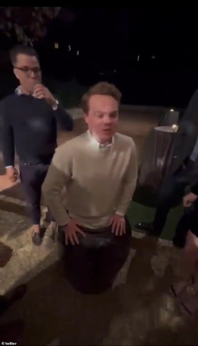 Revelers standing around him appear to try to help, but continue to hold their drinks as Connor, wearing a cream sweater over a white shirt, meanders in