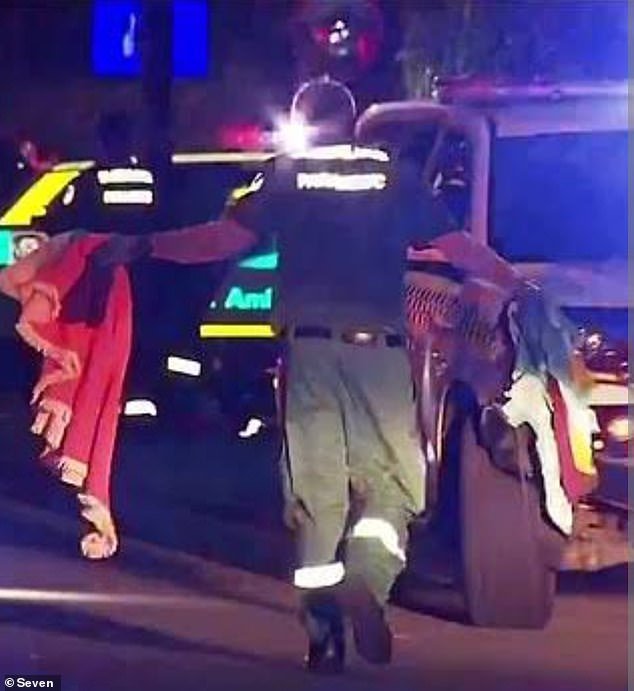 A paramedic removed what appears to be a fringed beach towel and clothing left on the road after Melissa Hoskins was injured and later died in Adelaide on December 30.