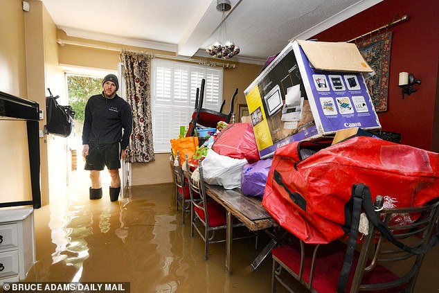 Matthew Bloodworth in his flooded home opposite Tewkesbury Abbey in Gloucestershire after Storm Henk hit Britain last week