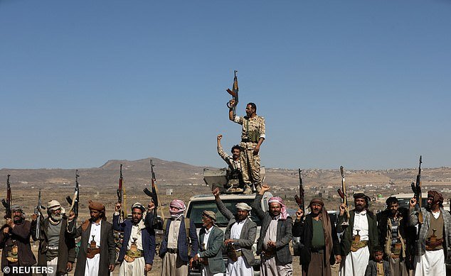 Houthi fighters and tribal supporters raise their firearms to protest US-led airstrikes